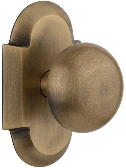 Arched Rosette Door Set with Classic Round Knobs in Antique Brass.
